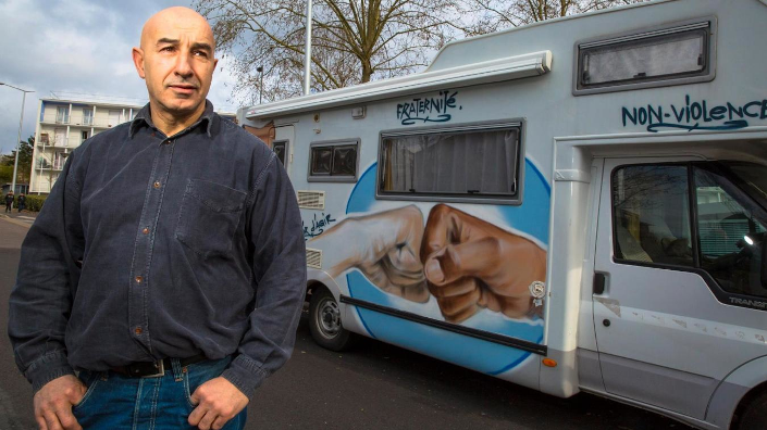 Yazid Kherfi devant le camping car graffé qui lui sert à sillonner la France